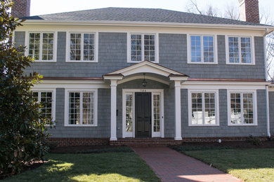 Imagen de fachada de casa gris clásica de tamaño medio de dos plantas con revestimientos combinados y tejado de teja de madera