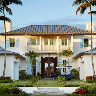 Island style beige two-story exterior home photo in Miami with a hip roof