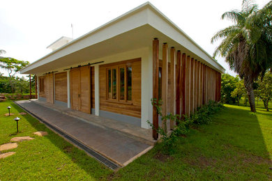 Inspiration for a small world-inspired bungalow house exterior in Other with wood cladding and a flat roof.