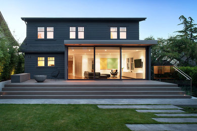 This is an example of a medium sized and gey modern house exterior in Vancouver with three floors and wood cladding.