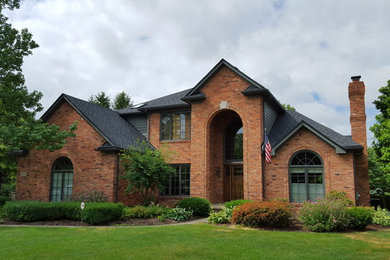 Exemple d'une grande façade de maison rouge chic en bois à un étage avec un toit à quatre pans.