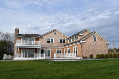 Foto de fachada de casa marrón costera grande de dos plantas con revestimiento de madera, tejado a dos aguas y tejado de teja de madera