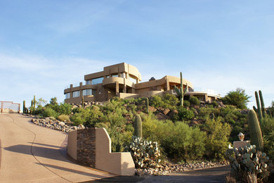 Inspiration for a large contemporary beige three-story stucco exterior home remodel in Phoenix