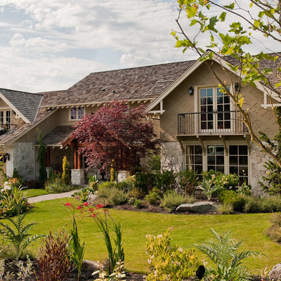Large traditional beige two-story stone exterior home idea in Seattle