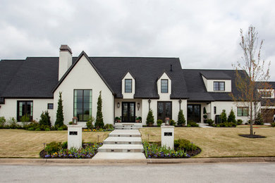 На фото: белый, большой, двухэтажный частный загородный дом в стиле неоклассика (современная классика) с двускатной крышей и крышей из гибкой черепицы
