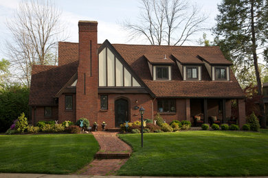 Immagine della facciata di una casa rossa classica a due piani di medie dimensioni con rivestimento in mattoni