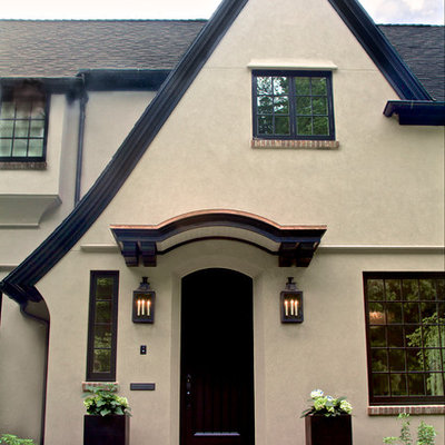 Large elegant beige three-story stucco exterior home photo in Portland with a shingle roof
