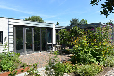 Diseño de fachada de casa moderna de tamaño medio de una planta con revestimiento de ladrillo y tejado plano
