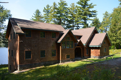 Modelo de fachada de casa marrón rústica extra grande de tres plantas con revestimiento de madera, tejado a dos aguas y tejado de teja de madera