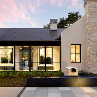 Example of a large minimalist beige one-story stucco house exterior design in San Francisco with a metal roof