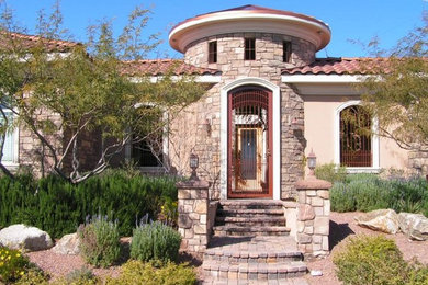 Example of a mid-sized tuscan beige one-story mixed siding house exterior design in Las Vegas with a hip roof and a tile roof
