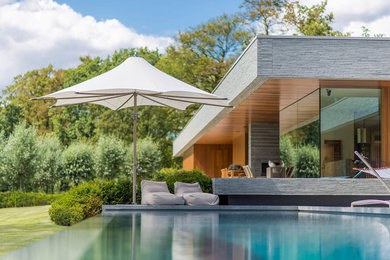 Diseño de fachada de casa marrón minimalista grande de una planta con revestimientos combinados y tejado plano