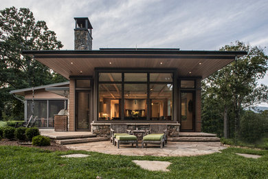 Modelo de fachada de casa gris tradicional renovada grande de tres plantas con revestimiento de madera y tejado de metal