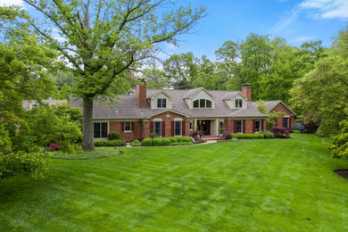 Example of a large classic two-story brick exterior home design in St Louis with a shingle roof