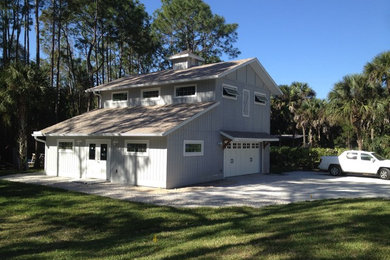 This is an example of a large and gey traditional two floor house exterior in Tampa with wood cladding and a pitched roof.