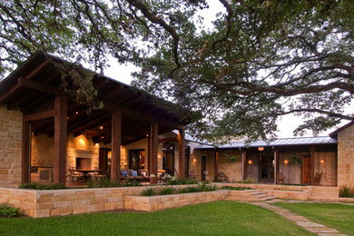 Large contemporary bungalow house exterior in Austin with stone cladding and a pitched roof.