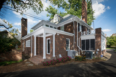 Large elegant brick house exterior photo in Columbus with a hip roof and a mixed material roof
