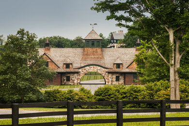 Imagen de fachada de casa marrón actual grande de dos plantas con revestimientos combinados, tejado a dos aguas y tejado de teja de madera
