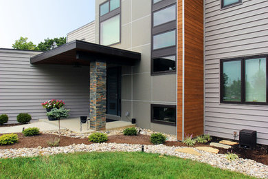 Modelo de fachada gris contemporánea grande de dos plantas con revestimiento de vinilo