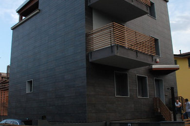 Esempio della facciata di una casa nera moderna a tre piani di medie dimensioni con rivestimento in legno
