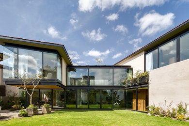 Diseño de fachada beige minimalista grande de dos plantas con revestimiento de piedra