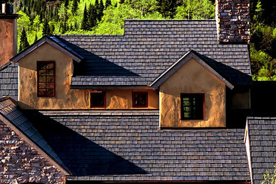 Modelo de fachada de casa beige rústica grande de dos plantas con revestimientos combinados, tejado de un solo tendido y tejado de teja de madera