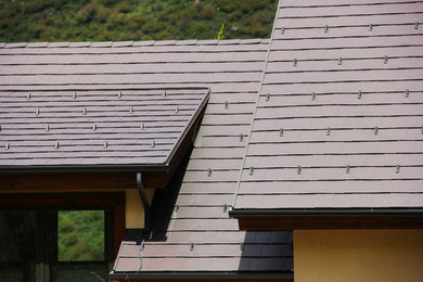 Ejemplo de fachada de casa gris rural grande de dos plantas con revestimientos combinados, tejado de un solo tendido y tejado de teja de barro