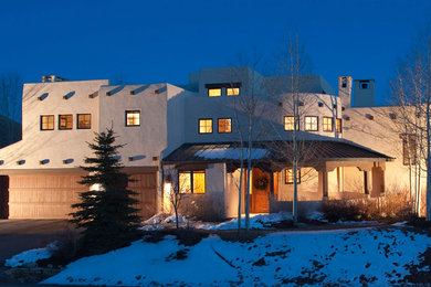 デンバーにあるラグジュアリーな巨大なサンタフェスタイルのおしゃれな家の外観 (漆喰サイディング) の写真