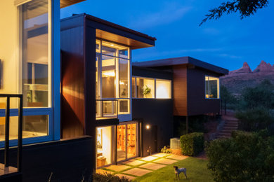 Ejemplo de fachada de casa marrón minimalista de tamaño medio de dos plantas con revestimiento de metal y tejado plano
