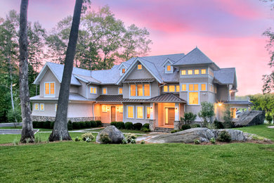 Imagen de fachada de casa beige marinera grande de tres plantas con revestimiento de madera, tejado a dos aguas y tejado de teja de madera
