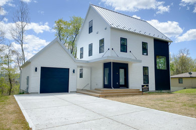 Foto de fachada de casa negra y blanca actual pequeña de tres plantas con revestimiento de vinilo, tejado de metal y tablilla