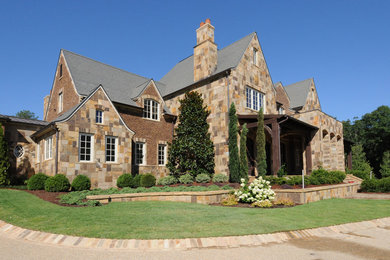 Inspiration for a large brown three-story stone house exterior remodel in Other
