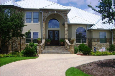 Modelo de fachada de casa beige clásica grande de dos plantas con revestimientos combinados, tejado a cuatro aguas y tejado de metal