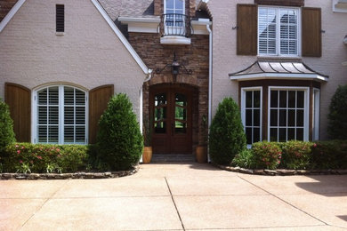 Imagen de fachada de casa beige clásica grande de dos plantas con revestimientos combinados
