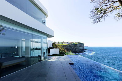 Inspiration for a contemporary white two-story stucco flat roof remodel in Sydney