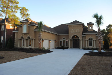 Example of a mid-sized tuscan brown two-story stucco house exterior design in Other with a hip roof and a shingle roof