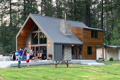 Zweistöckiges Modernes Einfamilienhaus mit grauer Fassadenfarbe, Satteldach, Blechdach und Metallfassade in Sonstige