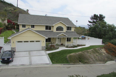 This is an example of a medium sized and yellow traditional two floor render house exterior in Los Angeles with a pitched roof.