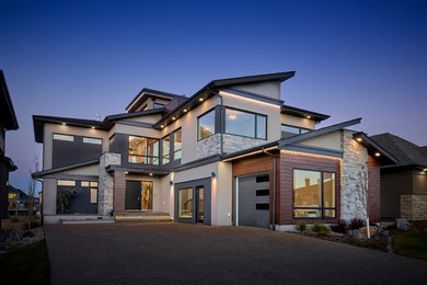 Diseño de fachada de casa gris contemporánea de tamaño medio de tres plantas con revestimiento de estuco, tejado de un solo tendido y tejado de teja de madera