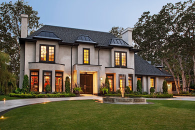 Large traditional beige two-story stucco house exterior idea in Vancouver with a shingle roof