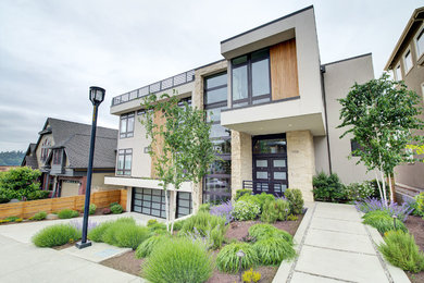 Example of a large trendy beige three-story mixed siding exterior home design in Seattle with a mixed material roof