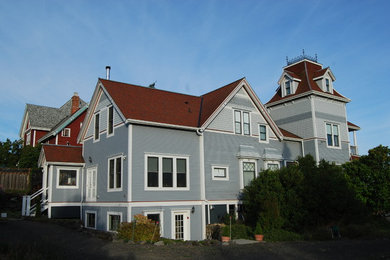 Ejemplo de fachada de casa gris tradicional grande de dos plantas con revestimiento de madera, tejado a dos aguas y tejado de teja de madera