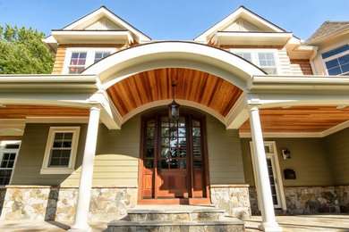 Photo of a large traditional two floor house exterior in DC Metro with wood cladding.