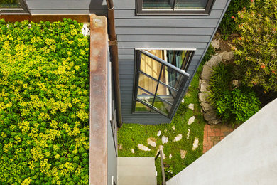 Cette image montre une façade de maison grise design en panneau de béton fibré.