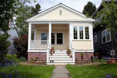 Example of a small classic yellow one-story concrete fiberboard gable roof design in Seattle