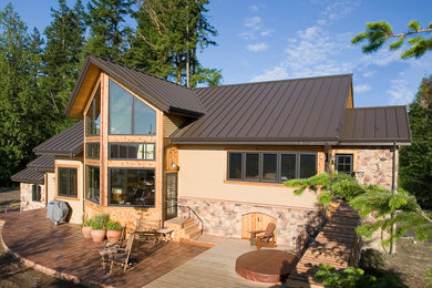 Diseño de fachada de casa multicolor de estilo americano de tamaño medio de dos plantas con revestimientos combinados, tejado a dos aguas y tejado de metal