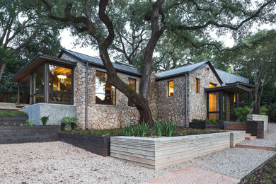 Large modern gray two-story stucco exterior home idea in Austin with a metal roof