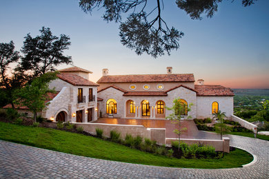 Example of a large tuscan two-story stone exterior home design in Austin