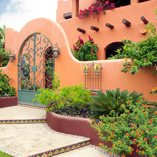 Inspiration pour une façade de maison orange méditerranéenne avec un revêtement en adobe.