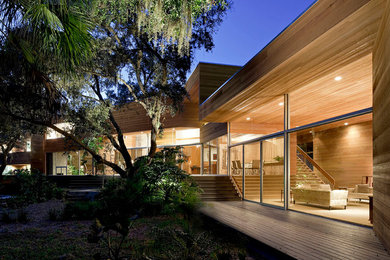 Modelo de fachada de casa beige minimalista de dos plantas con revestimiento de madera y tejado plano